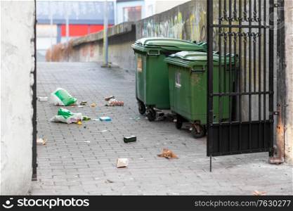 garbage, environment and waste disposal concept - dumpsters on messy city street or courtyard. dumpsters on messy city street or courtyard