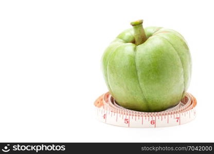 Garcinia Cambogia with measuring tape isolated on white background