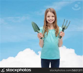 garden and people concept - smiling little girl with rake and scoop