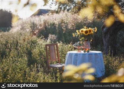 garden and still life - a vase with sunflowers and pears on a table with a white tablecloth