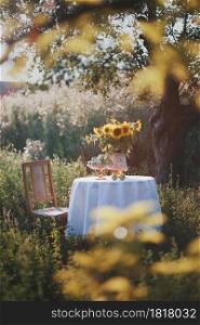 garden and still life - a vase with sunflowers and pears on a table with a white tablecloth