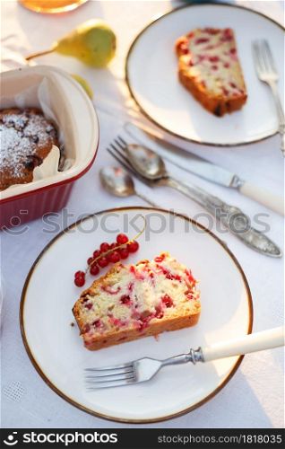 garden and still life. tea party in the garden - a piece of currant pie on a plate on a table with a white tablecloth
