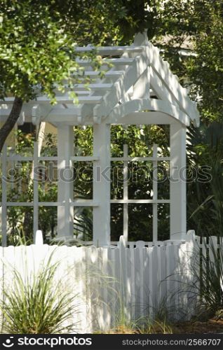 Garden arbor with white picket fence.