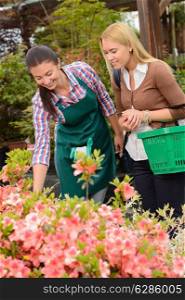 Garden center woman help customer with shopping basket choose flowers