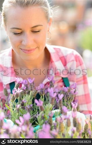 Garden center woman worker with purple potted plant