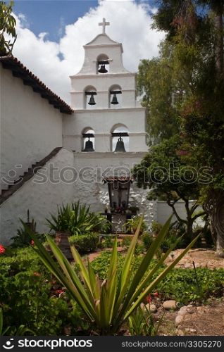 Garden of San Diego mission with statue at end of brick tiled path