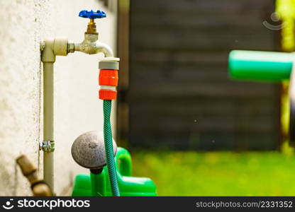 Garden outdoor tap with hosepipe attached.. Garden tap with hosepipe attached.