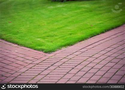 Garden stone path with grass growing up between and around stones, Brick Sidewalk