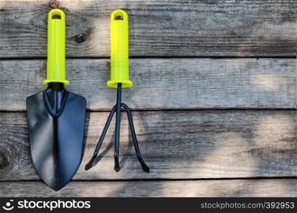 Garden tool shovel and rake on a wooden background. Garden tool shovel and rake on wooden background