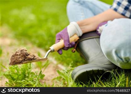 gardening and people concept - hand digging flowerbed ground with garden trowel. hand digging flowerbed ground with garden trowel