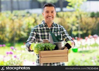 gardening and people concept - happy smiling middle-aged man with tools in box at summer garden. happy man with tools in box at summer garden