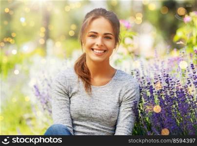 gardening and people concept - happy young woman with flowers at summer garden. young woman with flowers at summer garden