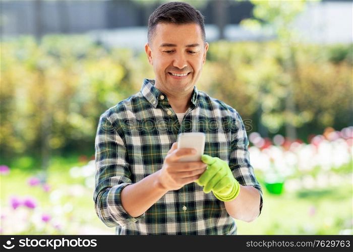 gardening and people concept - middle-aged man with smartphone at summer garden. happy man with smartphone at summer garden