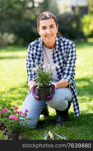 gardening and people concept - woman planting rose flowers at summer garden. woman planting rose flowers at summer garden