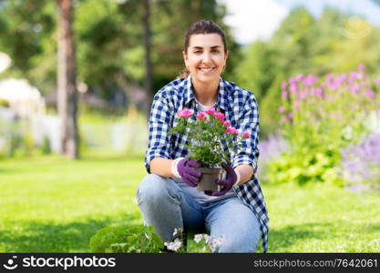 gardening and people concept - woman planting rose flowers at summer garden. woman planting rose flowers at summer garden