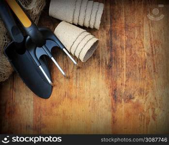 Gardening concept background with garden tools and pots on wooden background. Top view.. Gardening concept background with garden tools and pots on wooden background.
