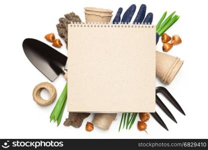 Gardening concept. Blank notebook over gardening tools isolated on white background. Copy space. Top view