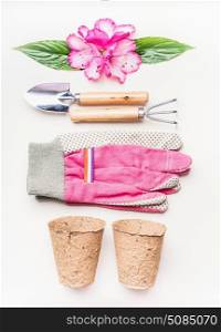 Gardening equipment flat lay for planting and weeding, with garden tools, flowers , pot on white table background, top view