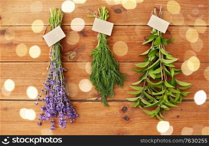 gardening, ethnoscience and herbs concept - bunches of lavender, dill and peppermint with name tags on wooden background. lavender, dill and peppermint on wooden background