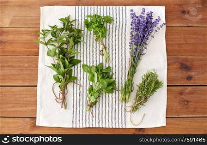 gardening, ethnoscience and organic concept - bunches of greens, spices or medicinal herbs on kitchen towel. greens, spices or medicinal herbs on towel