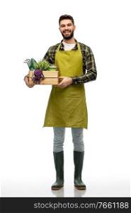 gardening, farming and people concept - happy smiling male gardener or farmer in apron and rubber boots with box of garden tools over white background. happy gardener or farmer with box of garden tools
