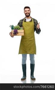 gardening, farming and people concept - happy smiling male gardener or farmer in apron and rubber boots with box of garden tools showing thumbs up over grey background. happy gardener or farmer with box of garden tools