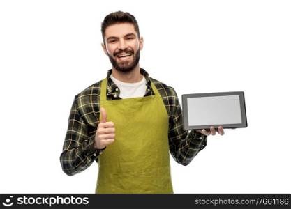 gardening, farming and technology concept - happy smiling male gardener or farmer in apron with tablet pc computer showing thumbs up over white background. happy male farmer with tablet pc showing thumbs up