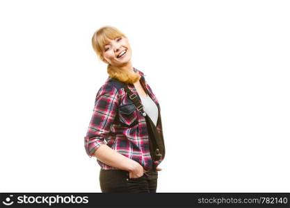 Gardening fashion concept. Laughing attractive woman in pink check shirt and dungarees, hands in pocket. Isolated background. Standing woman wearing dungarees laughing