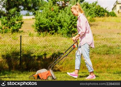 Gardening. Female person mowing green lawn with lawnmower in sunny day.. Gardening. Mowing lawn with lawnmower