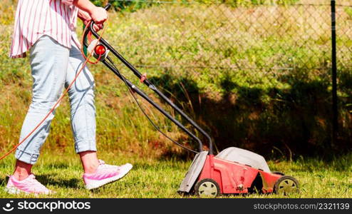 Gardening. Female person mowing green lawn with lawnmower in sunny day.. Gardening. Mowing lawn with lawnmower