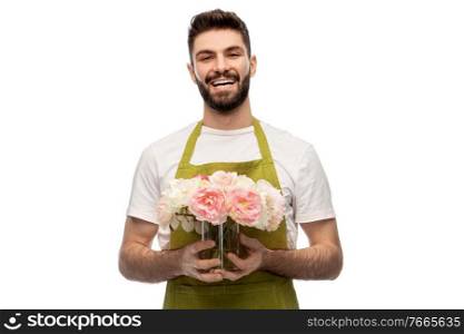 gardening, floristry and people concept - happy smiling male gardener in apron with bunch of peony flowers over white background. smiling male gardener with bunch of peony flowers