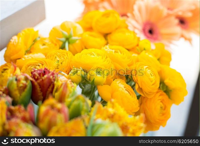 gardening, floristry, sale, holidays and flora concept - close up of beautiful yellow ranunculus flowers at flower shop