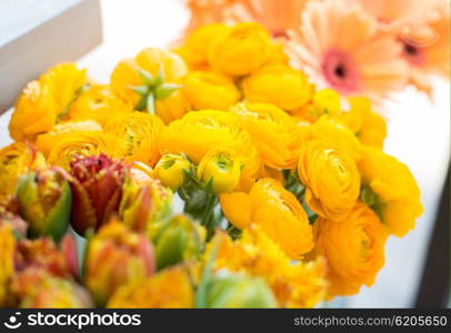 gardening, floristry, sale, holidays and flora concept - close up of beautiful yellow ranunculus flowers at flower shop