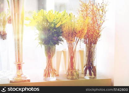 gardening, floristry, sale, holidays and flora concept - close up of flowers in vases at flower shop window. close up of flowers in vases at flower shop