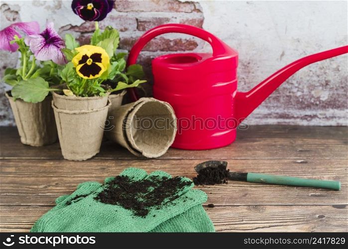 gardening flowers peat pots watering can shovel gardening gloves wooden desk