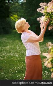 Gardening. Gracious Senior Woman and Flowers