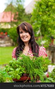 Gardening in summer - happy woman with different kind of fresh herbs