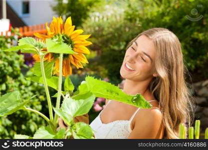 Gardening in summer - happy woman with flowers her garden