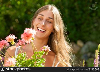 Gardening in summer - happy woman with flowers in her garden