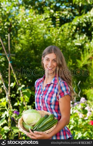 Gardening in summer - happy woman with freshly harvested vegetables