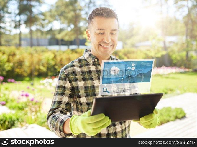 gardening, planting and technology concept - happy smiling man with tablet pc computer and virtual screen projection with growing chart at summer garden. man with tablet pc planting flowers in garden