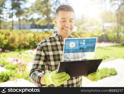 gardening, planting and technology concept - happy smiling man with tablet pc computer and virtual screen projection with growing chart at summer garden. man with tablet pc planting flowers in garden