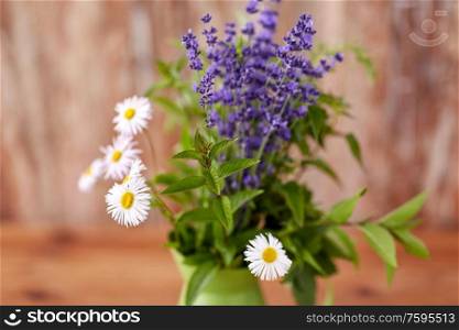 gardening, plants and organic concept - close up of bunch of herbs and flowers in green jug. close up of bunch of herbs and flowers