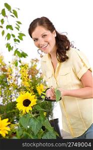 Gardening - smiling woman with sunflower and pruning shears on white background