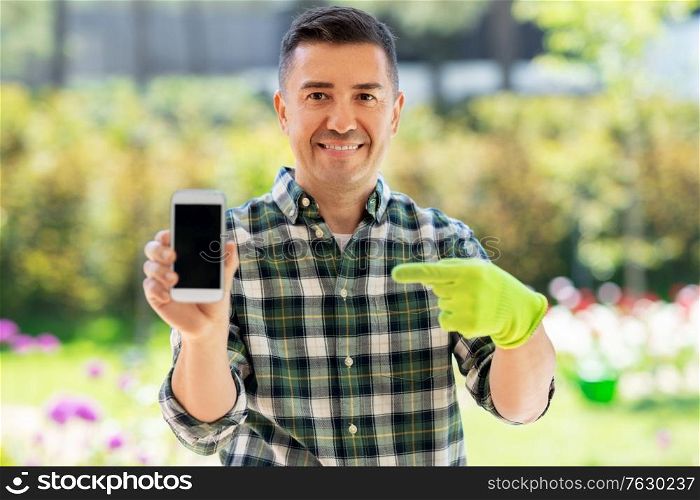 gardening, technology and people concept - happy smiling middle-aged man with smartphone at summer garden. middle-aged man with smartphone at summer garden