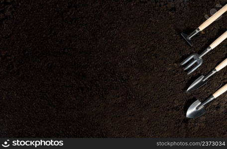 gardening tools and peat on soil background with copy space