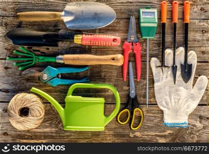 Gardening tools on wooden background flat lay. Gardening tools and watering can on wooden background flat lay top view.