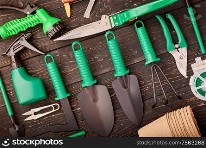 Gardening tools on wooden background flat lay top view