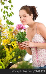 Gardening - woman holding flower pot smelling flower blossom on white background
