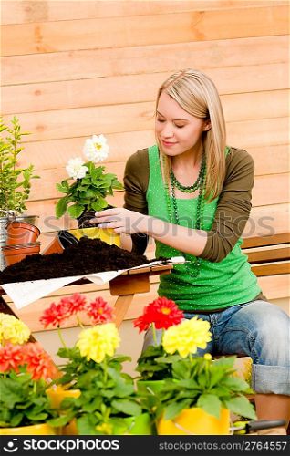 Gardening woman planting spring flower on terrace